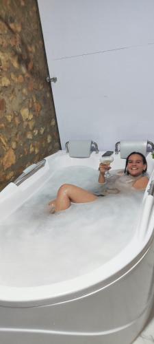 a woman is sitting in a bath tub at HOTEL EMPRESARIAL Arcoiris de mi llano in Paz de Ariporo