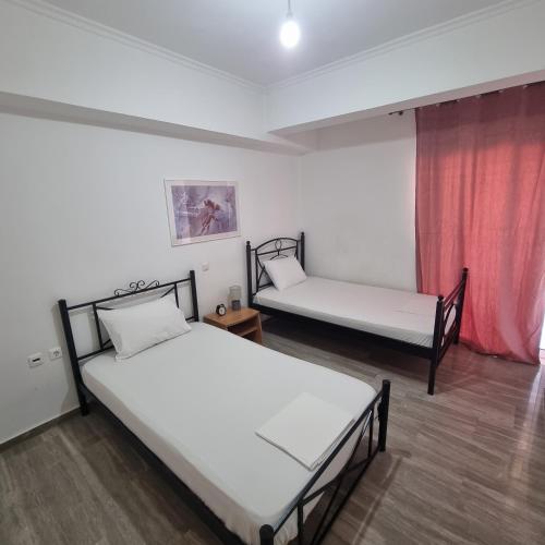 two beds in a room with a red curtain at Sea View apartment in Gythio