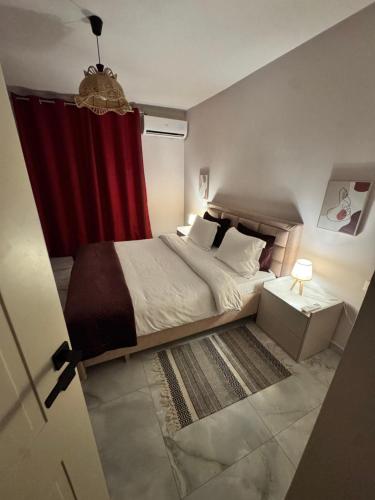 a bedroom with a bed with a red curtain at Downtown Deluxe Apartment in Shkodër