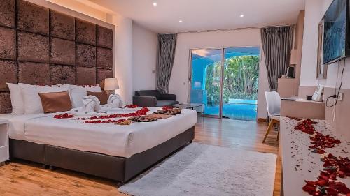 a bedroom with a large bed with red flowers on it at Pooh Beach Resort & Spa in Jomtien Beach