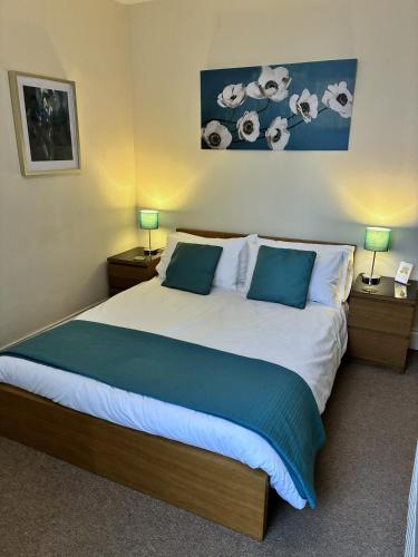 a bedroom with a large bed with two night stands at Historic Peel House Serviced Apartments in Burton upon Trent