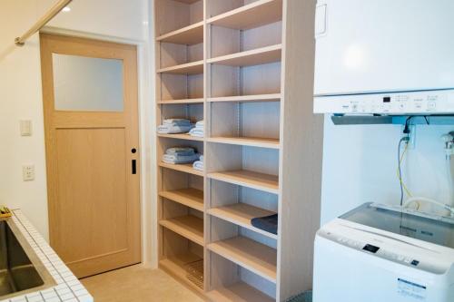 a kitchen with a pantry and a refrigerator at YMA House in Nago