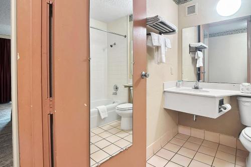 a bathroom with a sink and a toilet at Airport Inn Memphis Near Graceland By Hotel O in Memphis