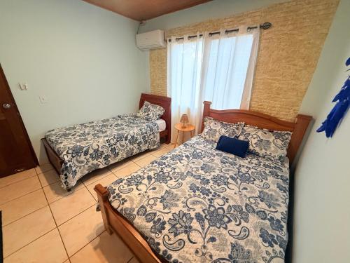 a bedroom with two beds and a window at BREEZE Hostal Boca Chica in Boca Chica