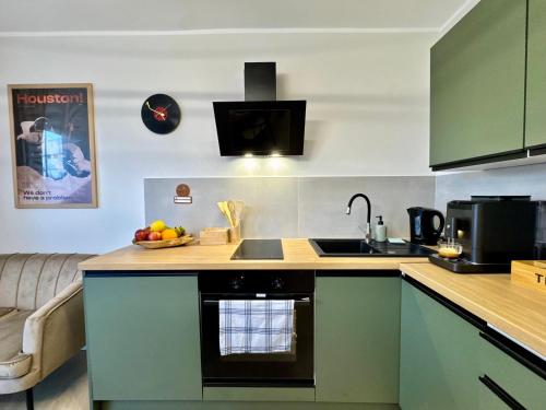 a kitchen with green cabinets and a bowl of fruit on the counter at Studio Jurasz I in Bydgoszcz