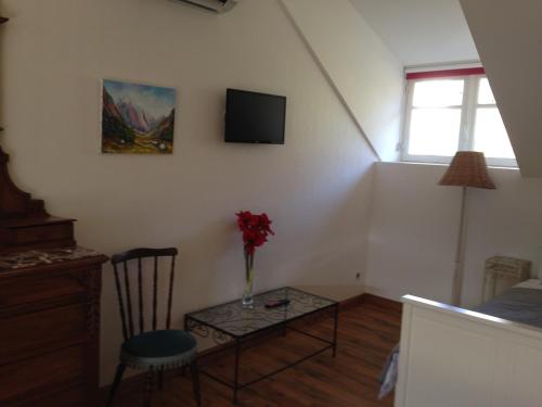 a room with a table with a vase of flowers on it at Villa l'Orante in Lourdes