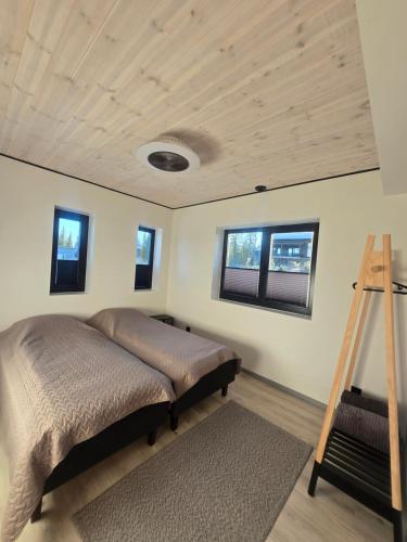 a bedroom with a bed and a wooden ceiling at Villa Remo Iso-Syöte in Syöte
