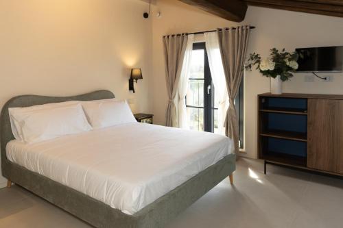 a bedroom with a bed and a tv and a window at Casa Gabri Boutique B&B Tuscan Villa retreat in Massa
