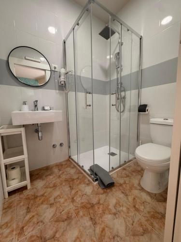 a bathroom with a shower and a toilet and a sink at Muxia Mare in Muxia
