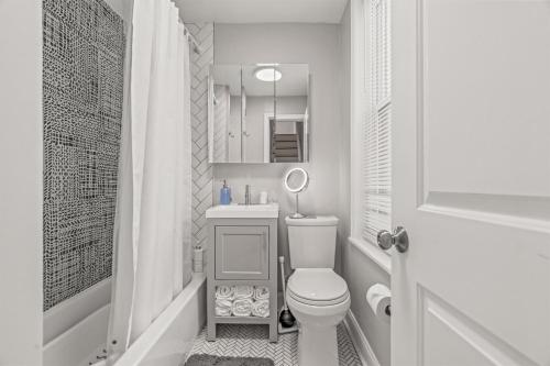 a white bathroom with a toilet and a sink at Pet Friendly- Big- King Bed Minutes 2 Stadiums in Philadelphia