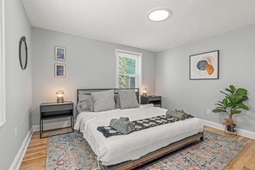 a white bedroom with a large bed and a rug at Pet Friendly- Big- King Bed Minutes 2 Stadiums in Philadelphia