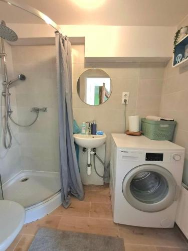 a bathroom with a washing machine and a sink at KissApartman in Kőszeg