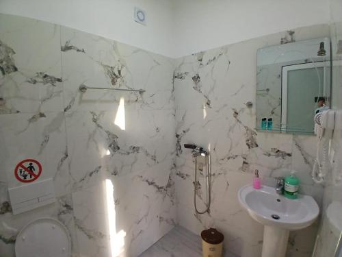 a white bathroom with a sink and a mirror at Hotel Bar Pizzeria Verona in Ksamil