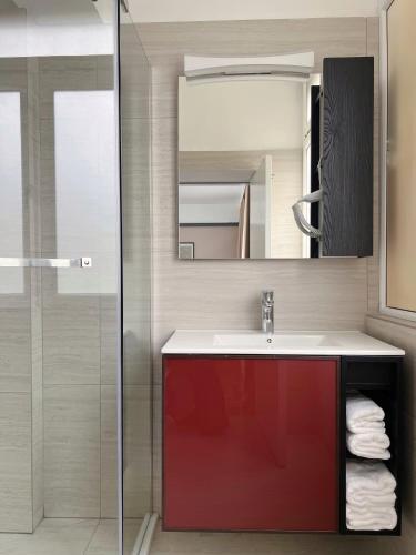 a bathroom with a red sink and a mirror at 2001 Central Stay in Peje