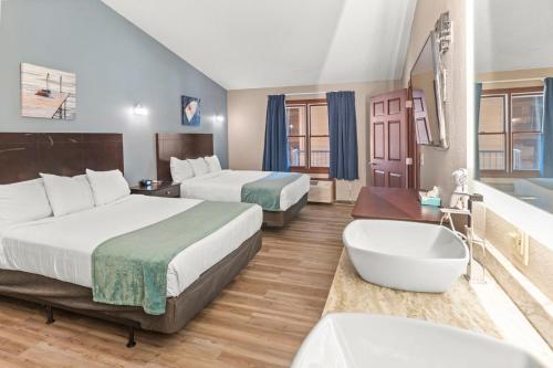 a hotel room with two beds and a bath tub at Edgewater Hotel and Suites in Put-in-Bay