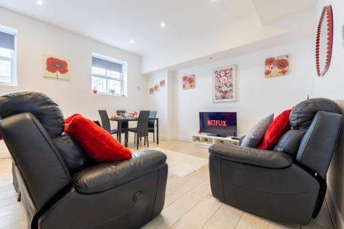 two black leather chairs in a living room with a table at Brighton Central Perfect Stays Walk to the Beach in Brighton & Hove