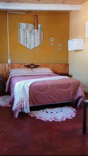 a large bed in a room with avertisementvertisement at Hospedaje La Casona de los Paredones in Charbonier