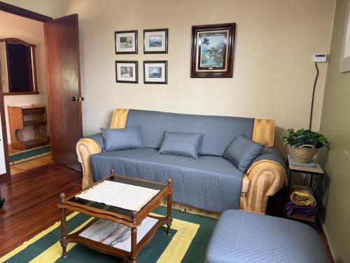 a living room with a blue couch and a table at A Casa da Playa do Con - Moaña in Moaña