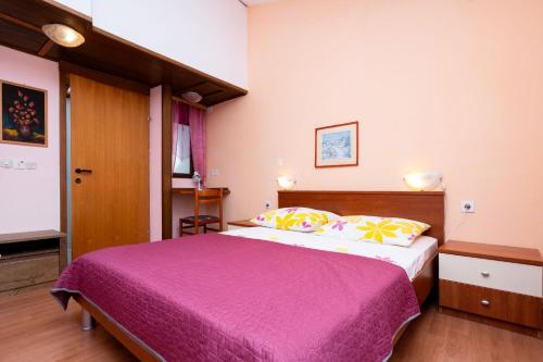 a bedroom with a large bed with a purple blanket at Apartment Bezerusa in Igrane