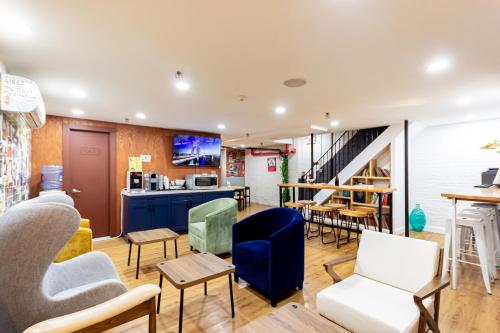 a living room with chairs and tables and a staircase at JGSTAY - Times Square in New York