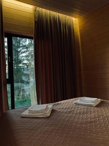 a bed in a room with a window with towels on it at Love's Mount Resort in Slavske