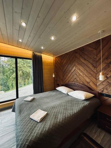 a large bed in a room with a large window at Love's Mount Resort in Slavske