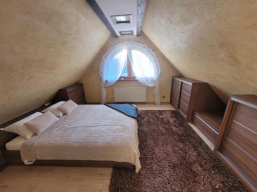 a attic bedroom with a bed and a window at Lake Hill Giżycko in Giżycko