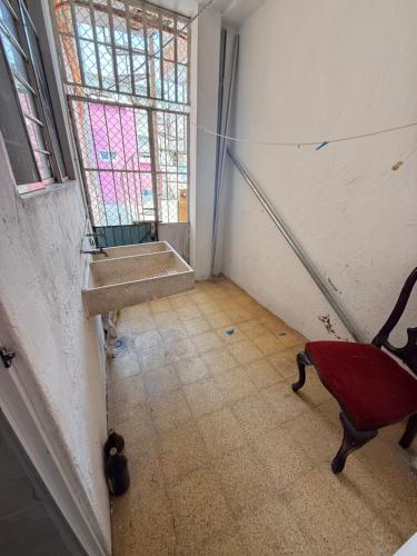 a room with a red chair and a window at Departamento completo bien ubicado in Minatitlán