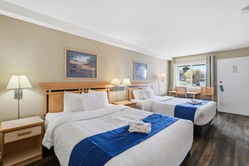 a hotel room with two beds and a window at Canada's Best Value Desert Inn & Suites in Cache Creek