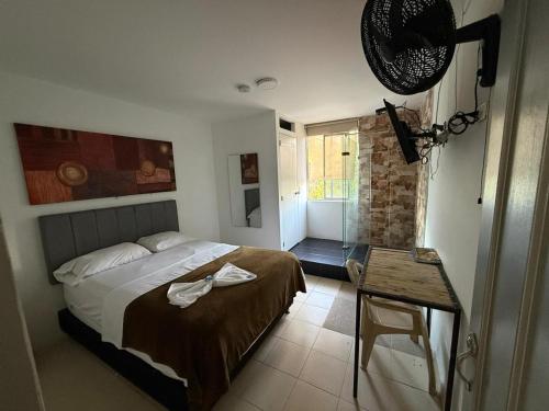 a bedroom with a bed and a table in it at Hotel Bayadera Real in Medellín