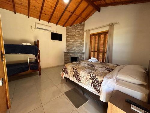 a bedroom with a bed and a television in it at Mini Fazenda Park in Santana do Livramento