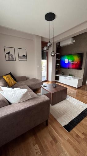 a living room with a couch and a flat screen tv at SiM Lux in Čačak