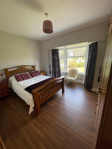 a bedroom with a bed and a chair and a window at Island Place in Castleisland