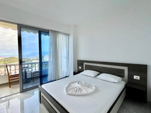 a bedroom with a bed with a view of a balcony at Hotel Joni Lukove in Lukovë