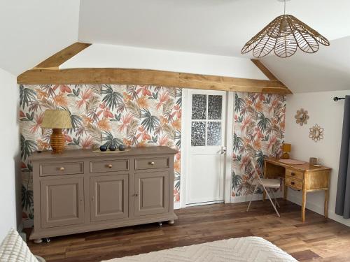 a bedroom with a dresser and a desk in a room at Gîte de La Petite Mauve in Baule