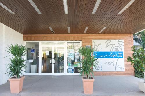a building with two potted plants in front of a door at Carlos III in Sant Carles de la Ràpita