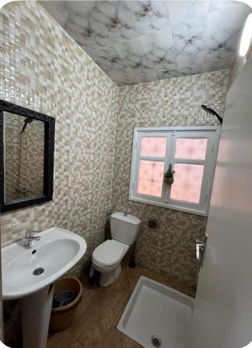 a bathroom with a sink and a toilet and a window at White House TAMRAGHT in Agadir