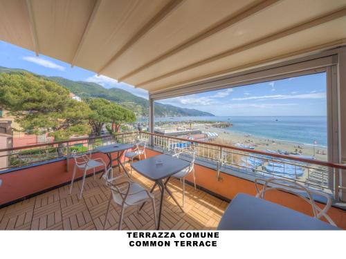 a balcony with tables and chairs and a view of the beach at Affittacamere Lo Scoglio in Monterosso al Mare