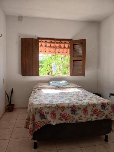 a bedroom with a bed and a window with a blanket at Quarto Privativo e Camping em Canoa Quebrada in Canoa Quebrada