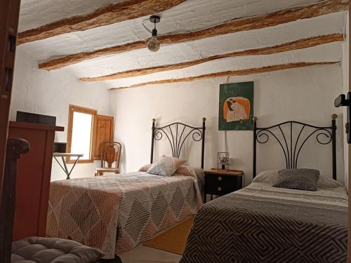 a bedroom with two beds in a room at El Bosquet 1897 in Mogente
