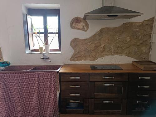 a kitchen with a counter and a sink and a window at El Bosquet 1897 in Mogente