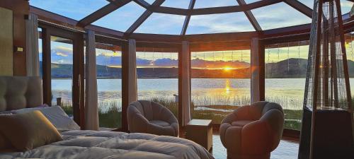 a bedroom with a large window with a view of the water at Los Uros in Puno