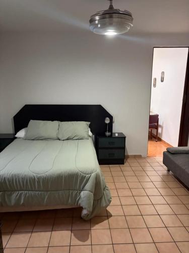 ein Schlafzimmer mit einem Bett und einem gefliesten Boden in der Unterkunft Depa B Bosques del Contry in Monterrey