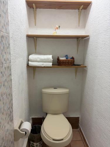 ein kleines Badezimmer mit Toilette und Handtüchern in der Unterkunft Depa B Bosques del Contry in Monterrey