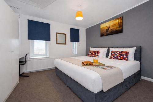 a bedroom with a large bed and a television at Central MK Apartment 2 Bedrooms Free Parking Ideal for Contractors & Business Travellers in Milton Keynes