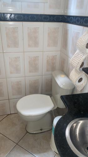 a bathroom with a white toilet and a sink at Condomínio azul in Paraty