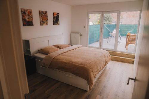 a bedroom with a bed and a sliding glass door at Cozy vibes deluxe in Antwerp