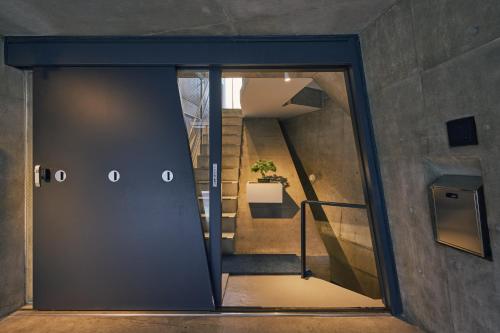 a glass door leading to a stairwell with a staircase at Crane Stay Shibuya in Tokyo