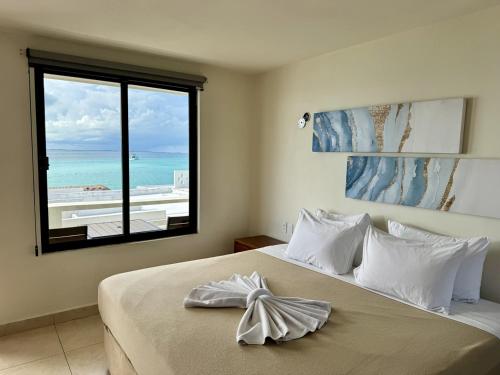 a bedroom with a bed with a view of the ocean at Charly Beach Hotel in Isla Mujeres