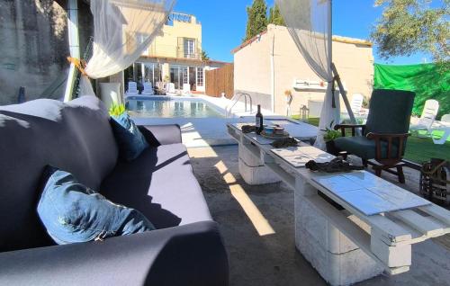 a patio with a couch and a table next to a pool at Cozy Home In Guillena in Guillena